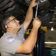 A mechanic inspecting a lifted car at a repair service station